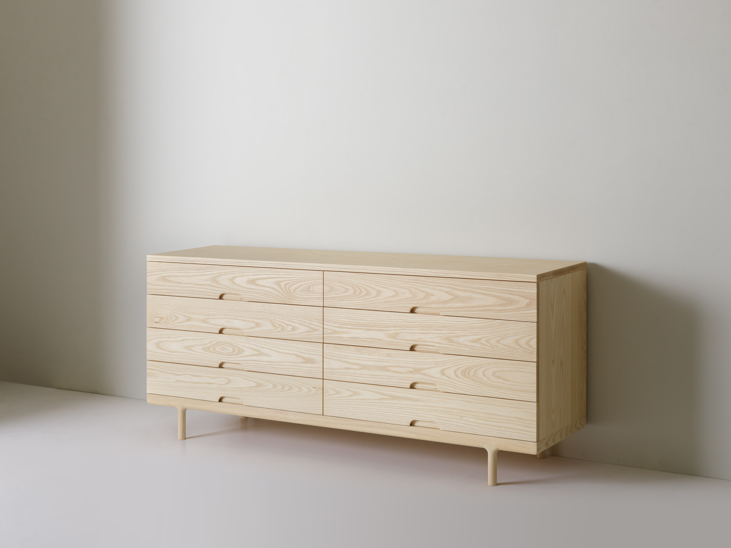 Close-up of the grain and drawer handles of the wooden dresser.