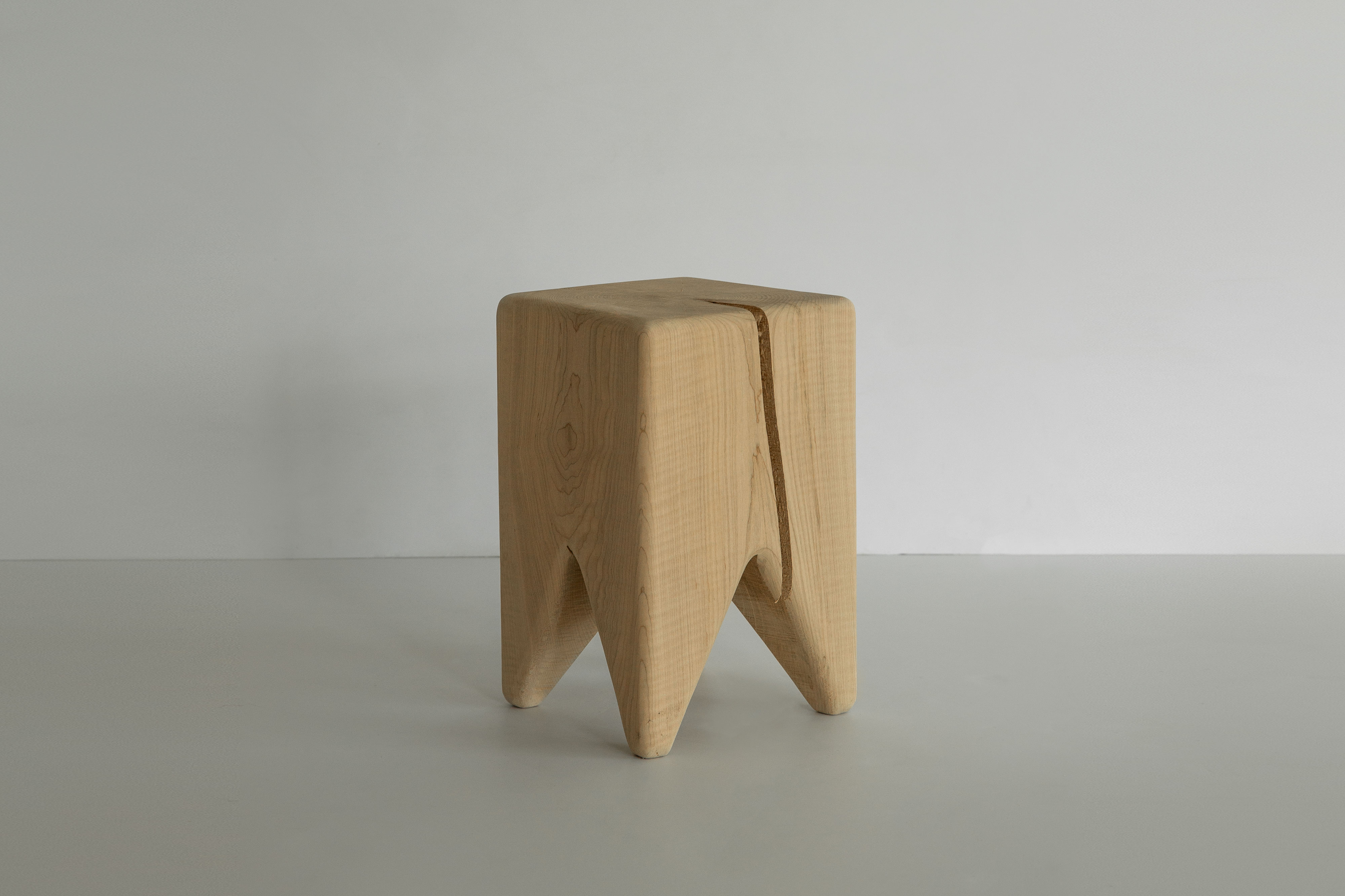 A framed piece of art leaning on a stool in a studio setting.