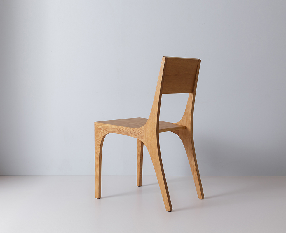 Single wooden chair with mid-century modern design, angled side view highlighting curved legs and back support.