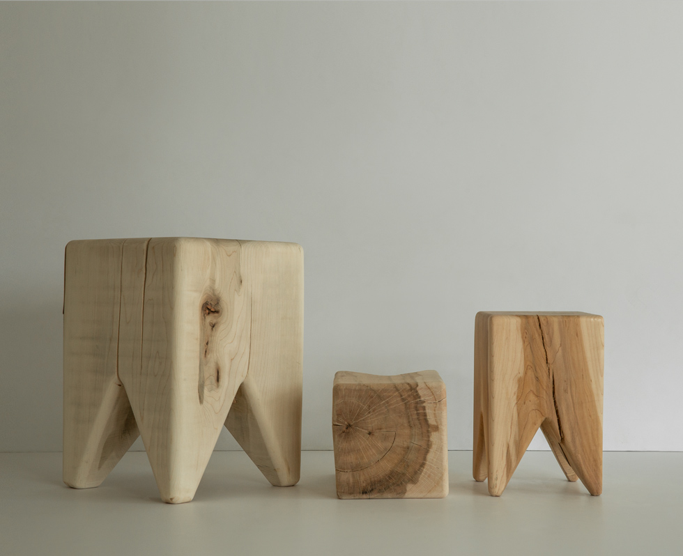 Two wooden stools of different sizes with a rustic finish on a clean surface.