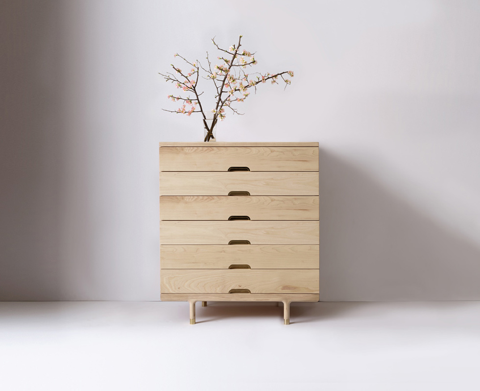Close-up of the drawer fronts showing curved brass pull handles and wood grain patterns.