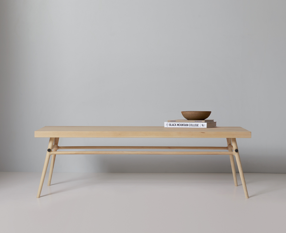 Close-up side view of the wooden bench showing its legs and horizontal supports.
