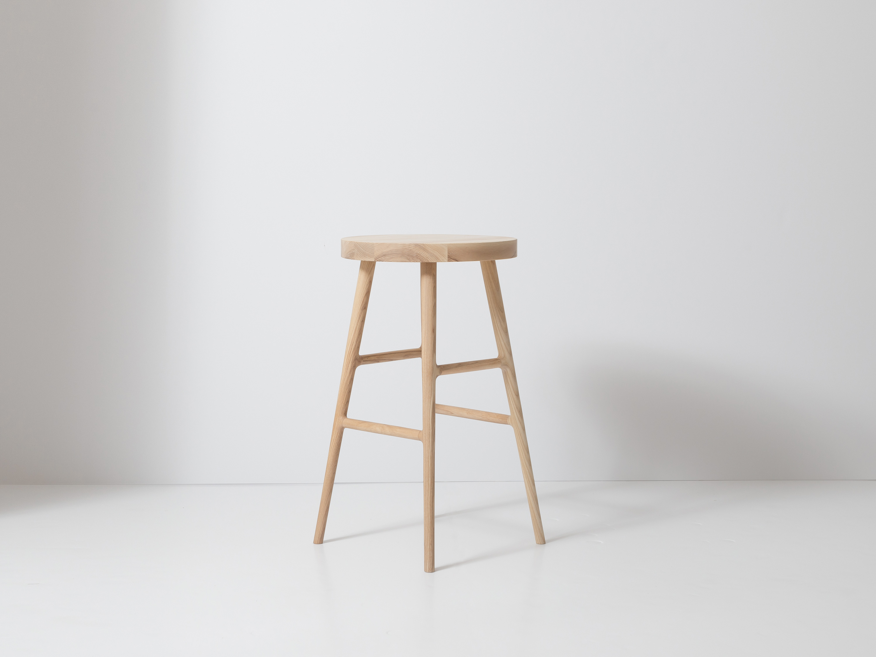 Single wooden stool against white backdrop