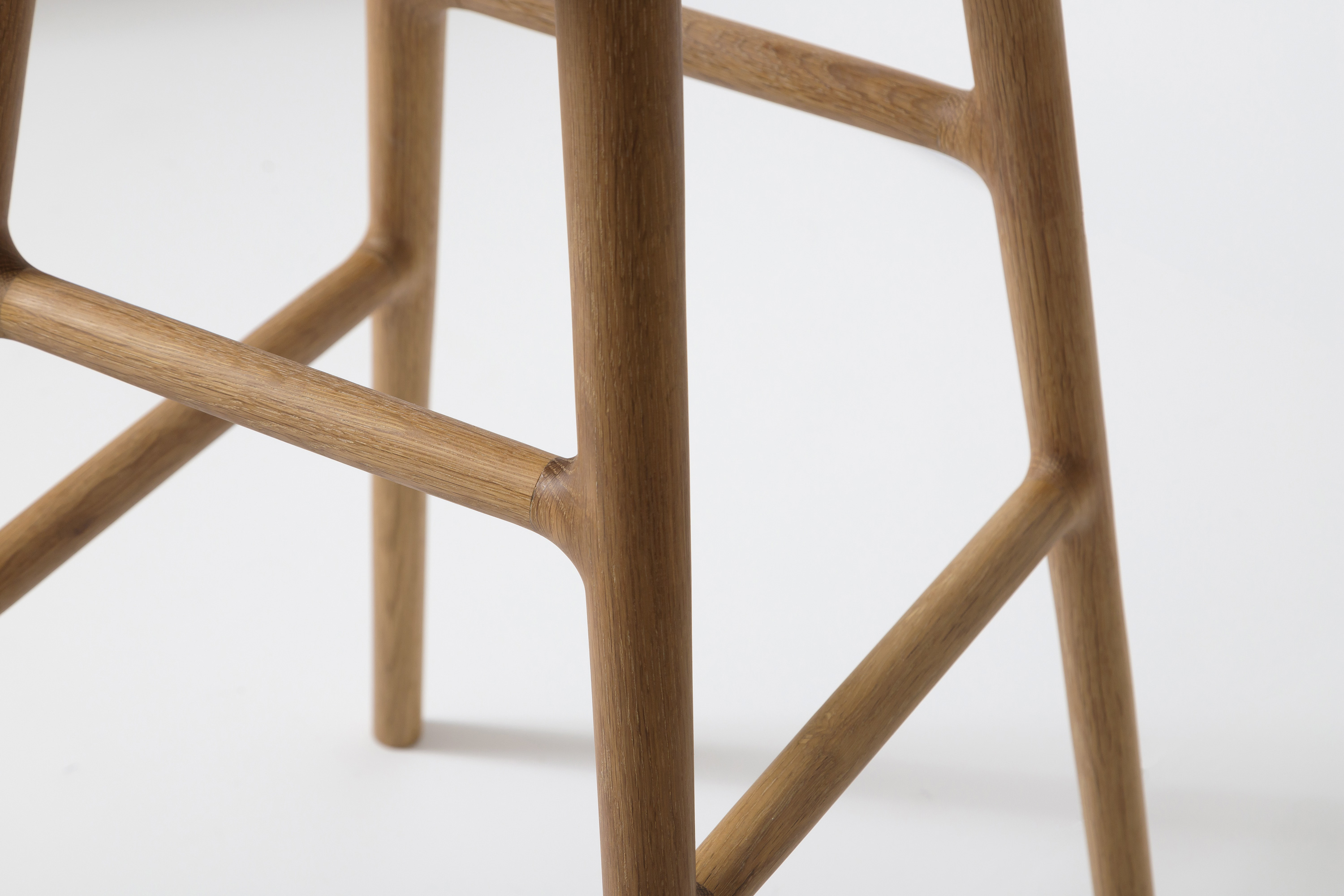 Three wooden stools in a row against pale background