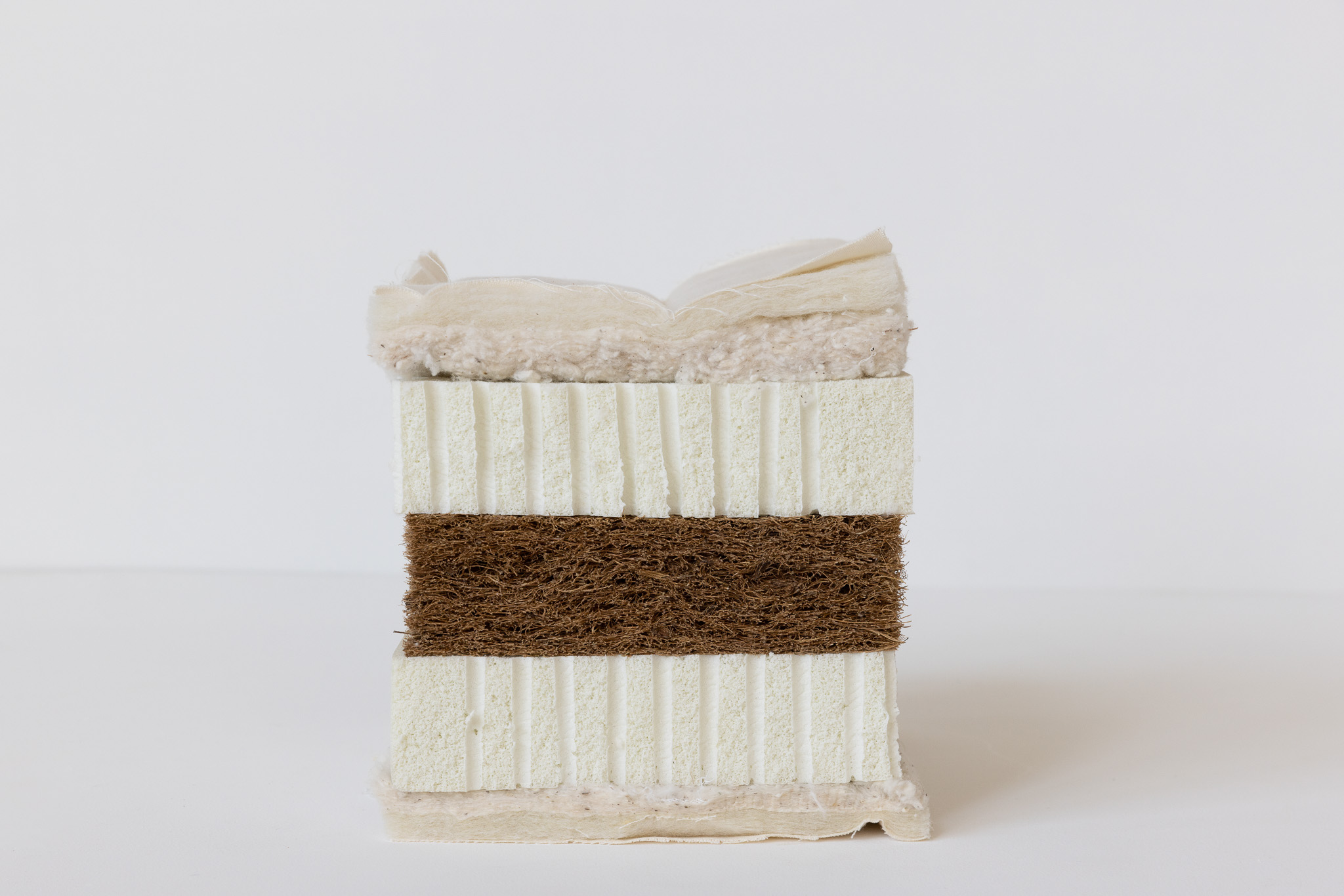 Front corner of a white memory foam mattress with quilted cover