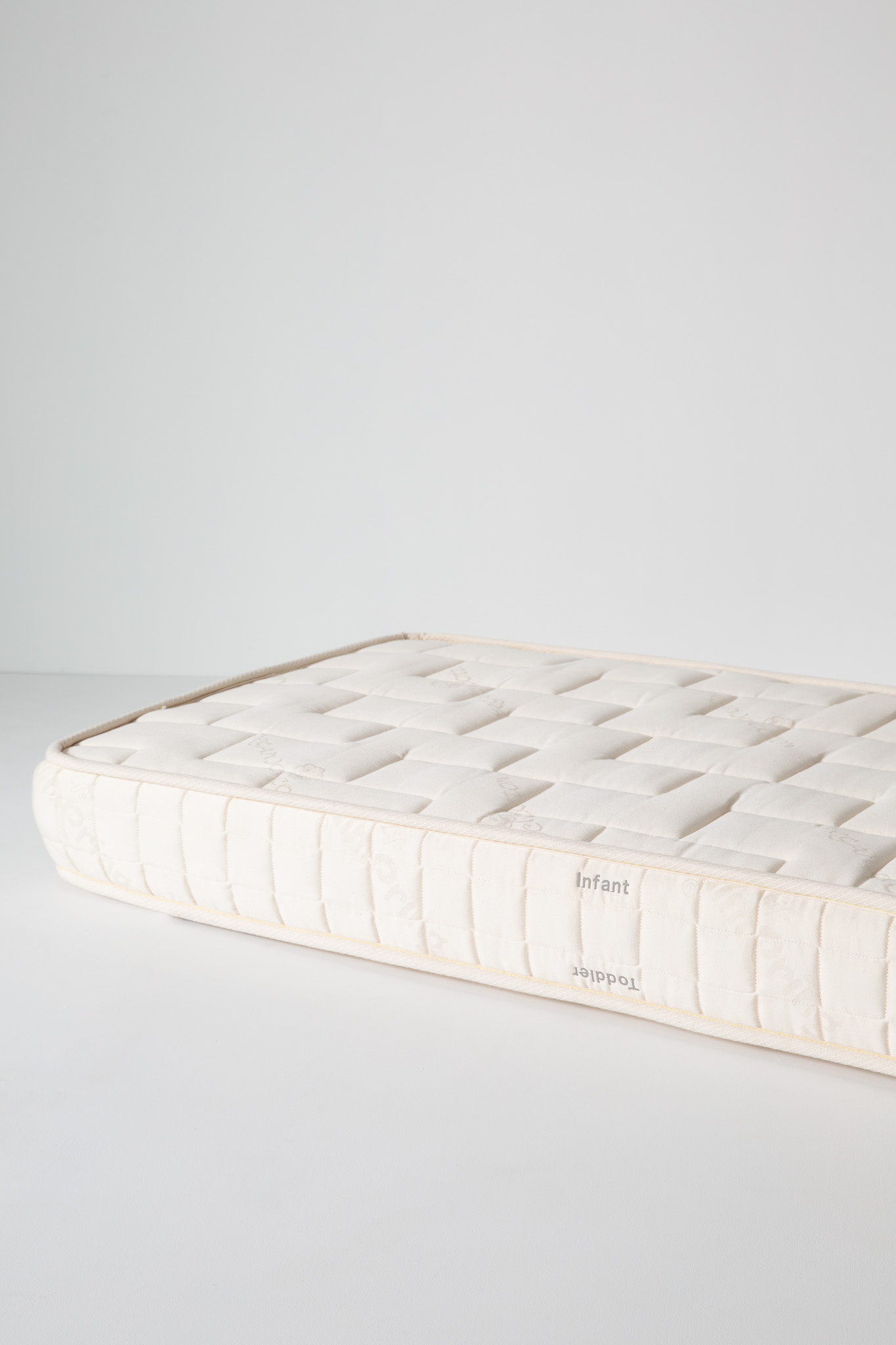 Top view of a white quilted mattress with visible corner seam and label reading Kalon.