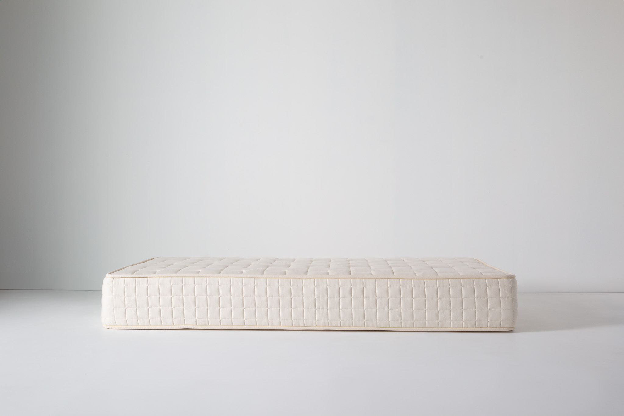 A white mattress with long rectangular shape, brand name Kalon on side