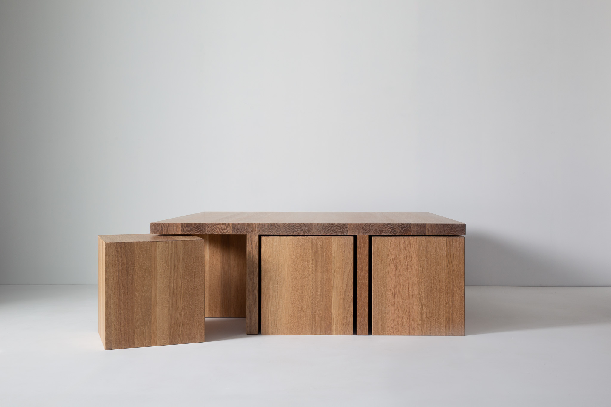 The same wooden table with low angle, showing three block-like legs as supports