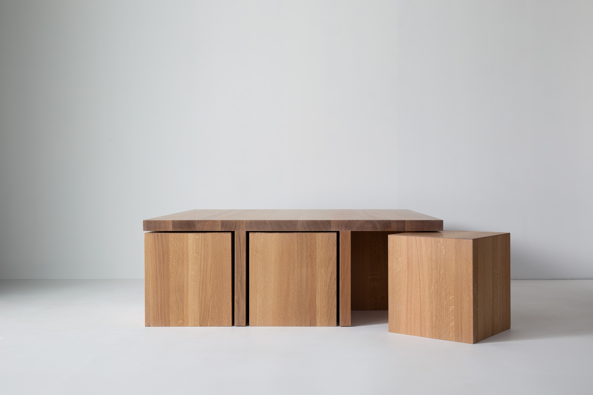Close-up of a modular wood coffee table with three box-like drawers/panels