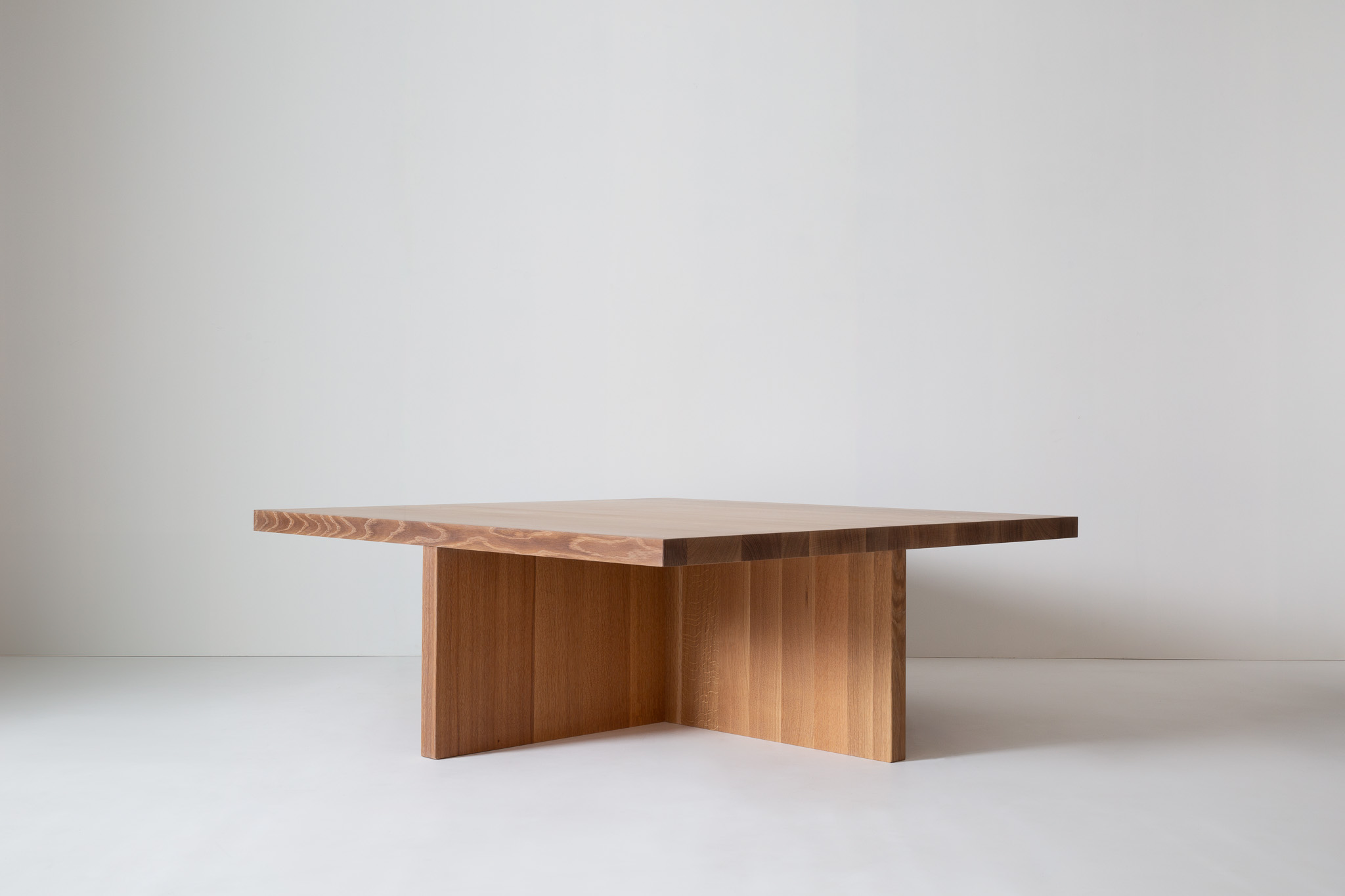 Table with two square stools placed on either side; stacks of books sit atop the table.