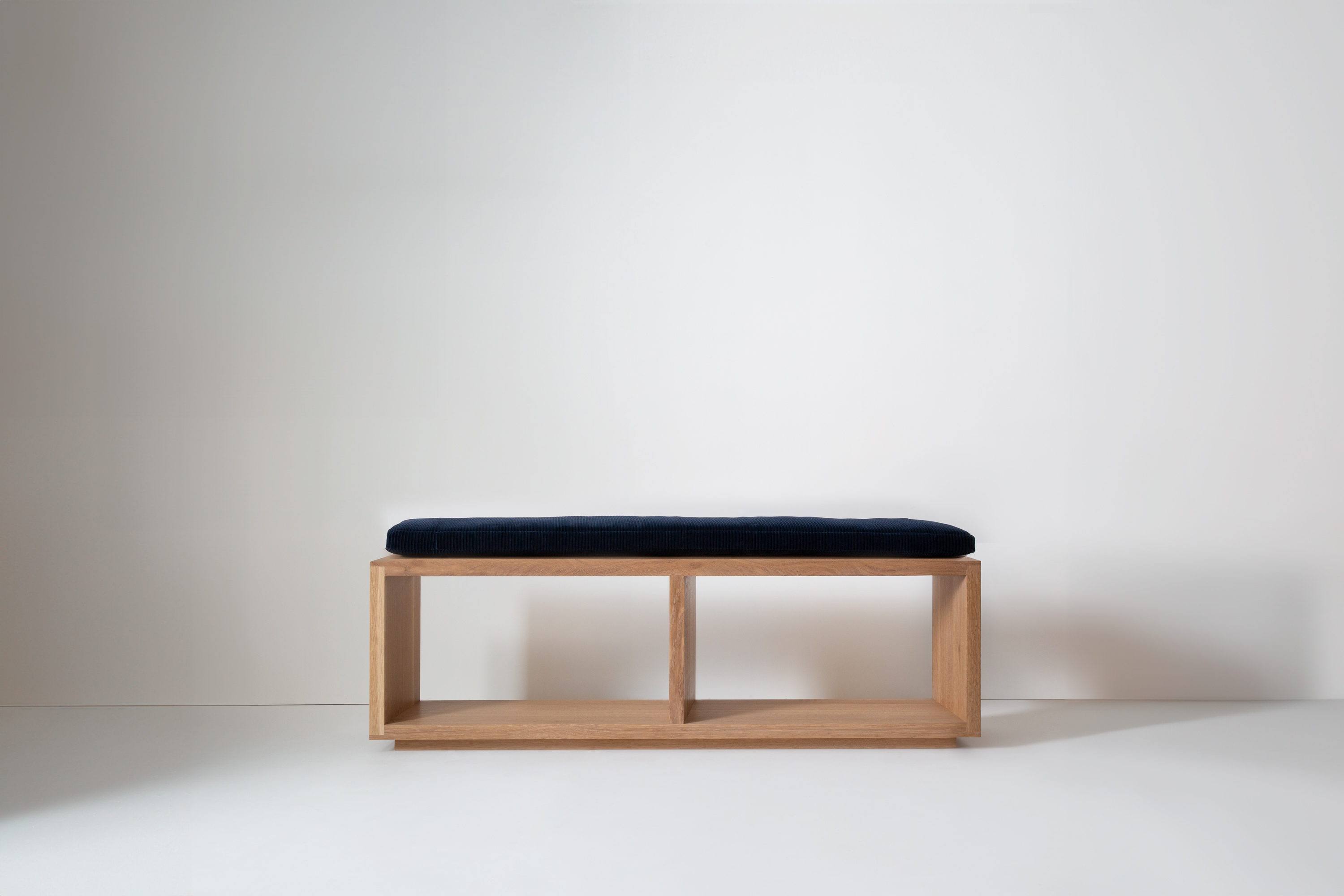 Close-up of bench with light and shadow patterns on wall